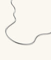 Boa Chain Necklace: A handcrafted sterling silver chain, resembling a coiled snake, displayed on a white surface. Ideal for making a bold statement.