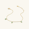 Baguette Gemstone Bracelet: A gold chain adorned with green stones, perfect for creating standout stackable looks.