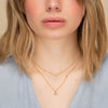 Woman wearing a Sapphire Choker around her neck, showcasing the elegant necklace designed for layering.