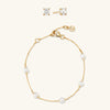 The Everyday Set: gold chain and pearl necklace, gold bracelet with pearls, and round topaz stud earrings.