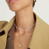 Woman wearing Tiny Pearl Necklace, an 18k gold vermeil piece with freshwater pearls, shown in a close-up of her neck and chin.