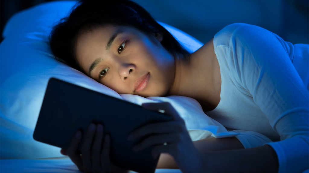 Woman checking her phone device before bed