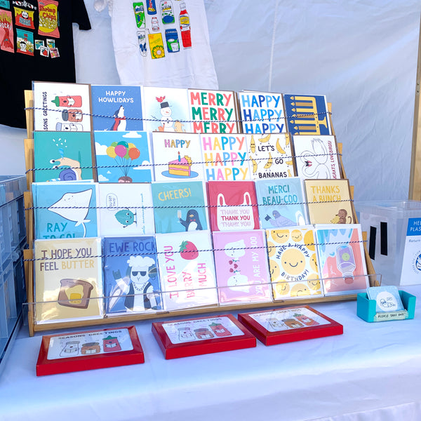 Photo of greeting card rack with colorful cards displayed including holiday ones.