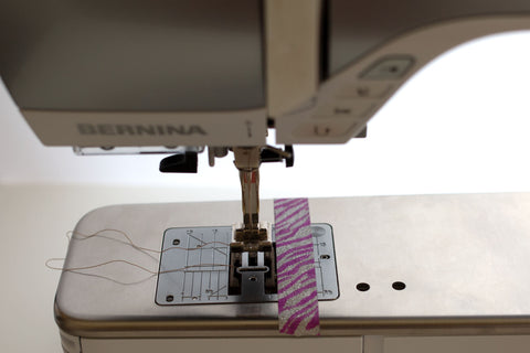 washi tape stuck to sewing machine plate to create measurement for 1/4" seam