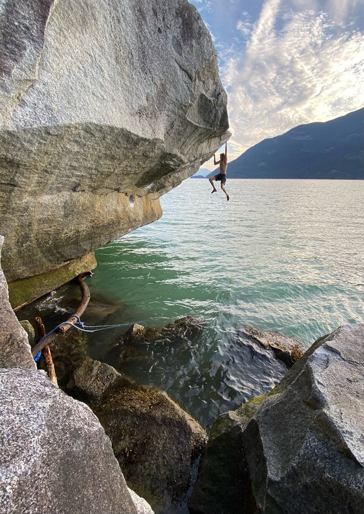 Will climbing a boulder above a lake. The boulder is Majestic (V6), Squamish, British Columbia © Sonnie Trotter