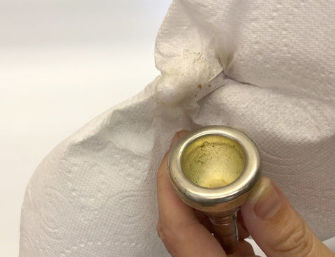 Cleaning the cup of a brass mouthpiece.