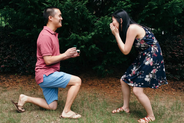 Guy proposing in a park