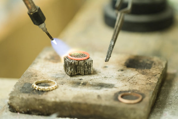 Ring being sautered by jeweler