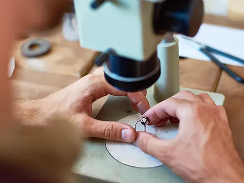 Jeweler looking at ring with microscope