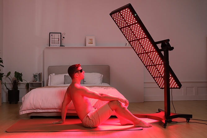 a relaxing man enjoy the red light with scinelodic red light therapy panel at home