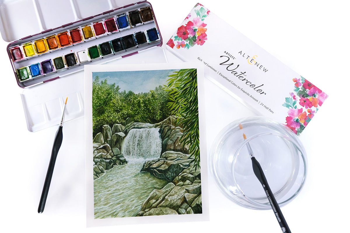 Nature-themed watercolor painting depicting a small waterfall, painted with Artistry's Artists' 24 Watercolor Pan Set