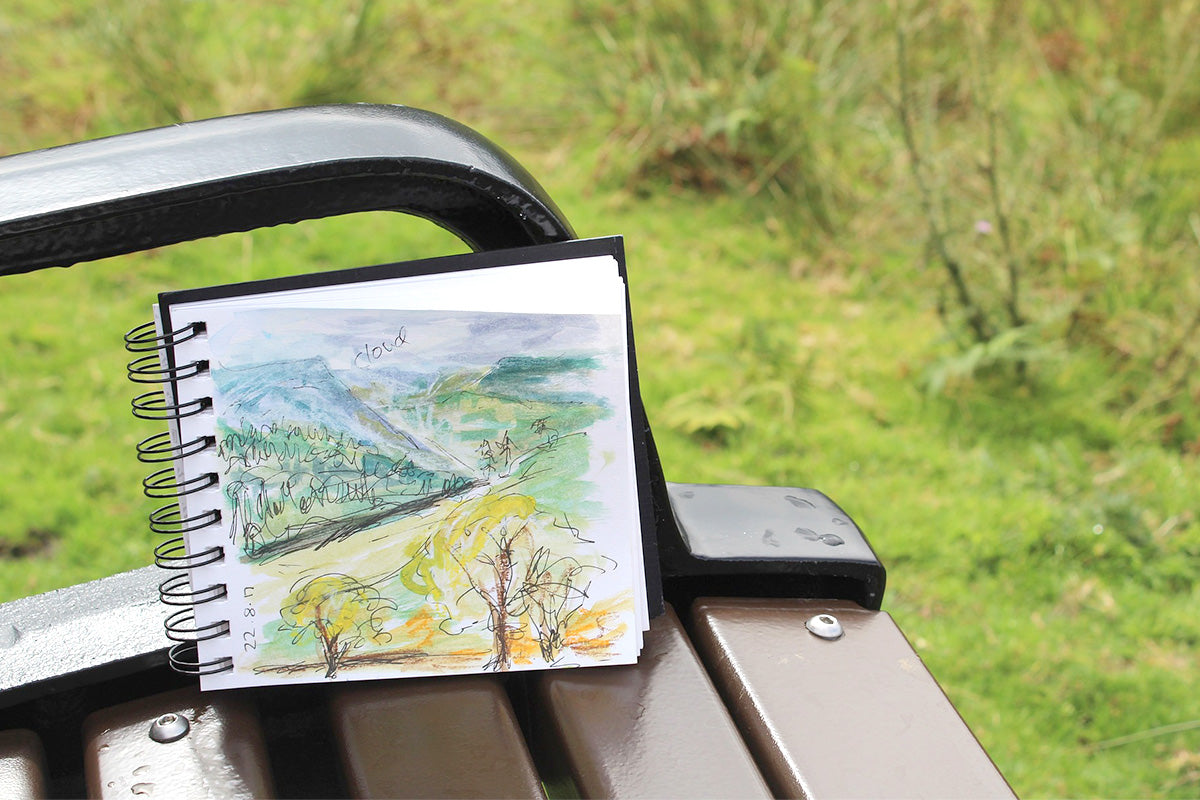 A sketchbook on a park bench