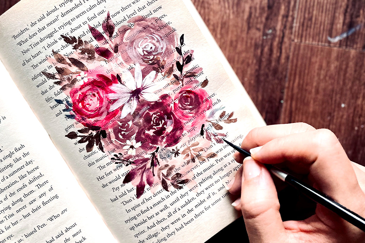 A beautiful floral painting on the page of a book, painted with Artistry by Altenew Gouache Paints