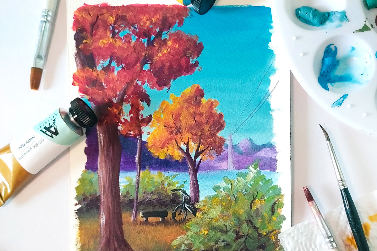 A gouache painting of an autumn scene with trees, foliage, and a lake, painted with Artists' Gouache from Artistry by Altenew