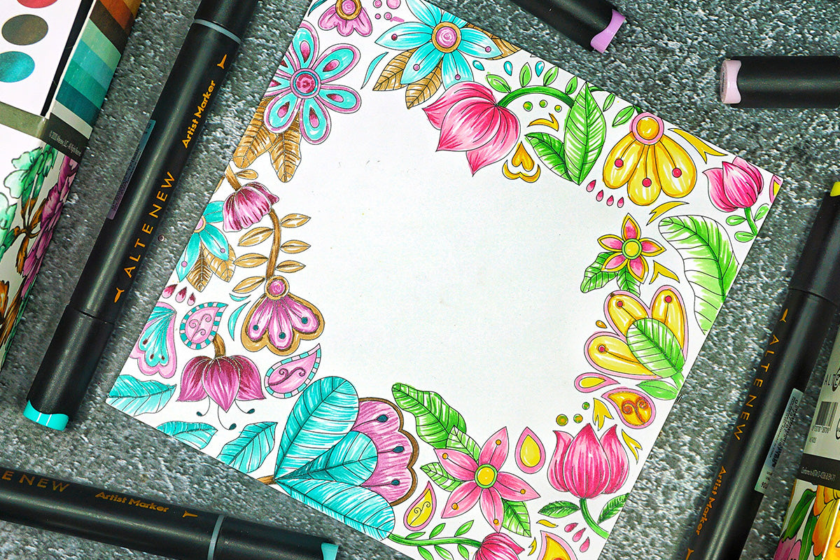 A piece of cardstock with a colorful border design of flowers, colored in with Altenew's Artists Markers