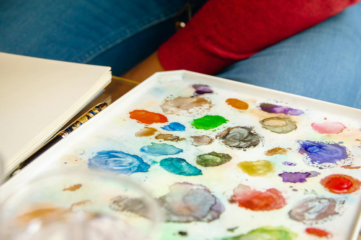 A photo of a painter's palette with a few blobs of watercolor paints