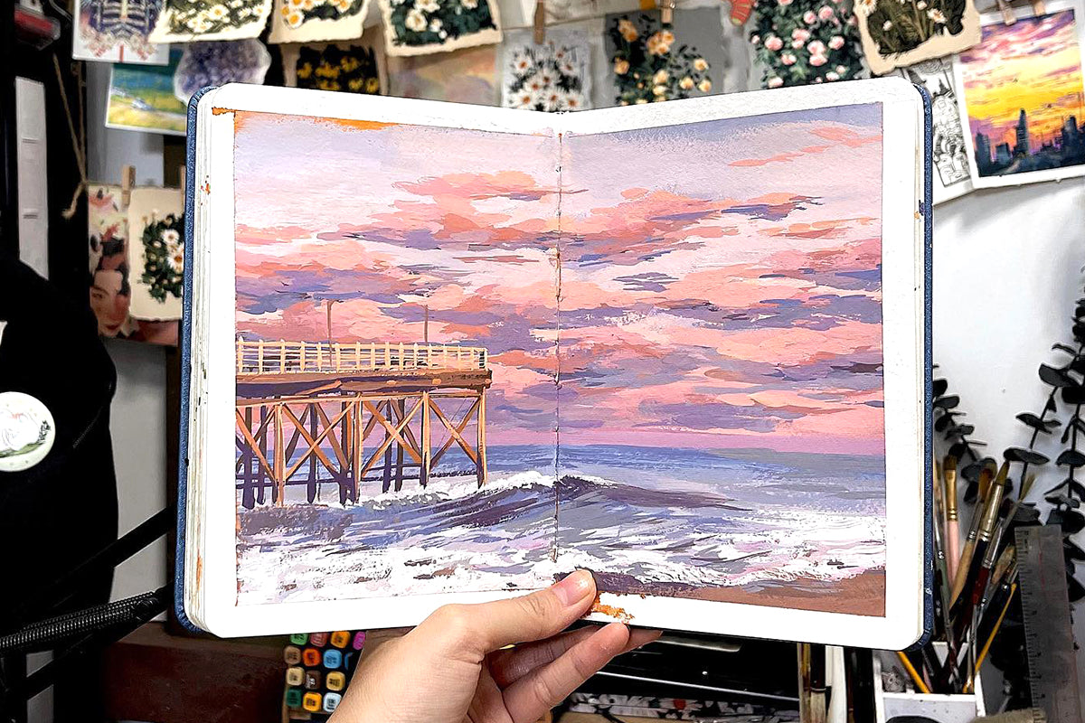 A gouache painting of a beach sunset with pink and blue hues