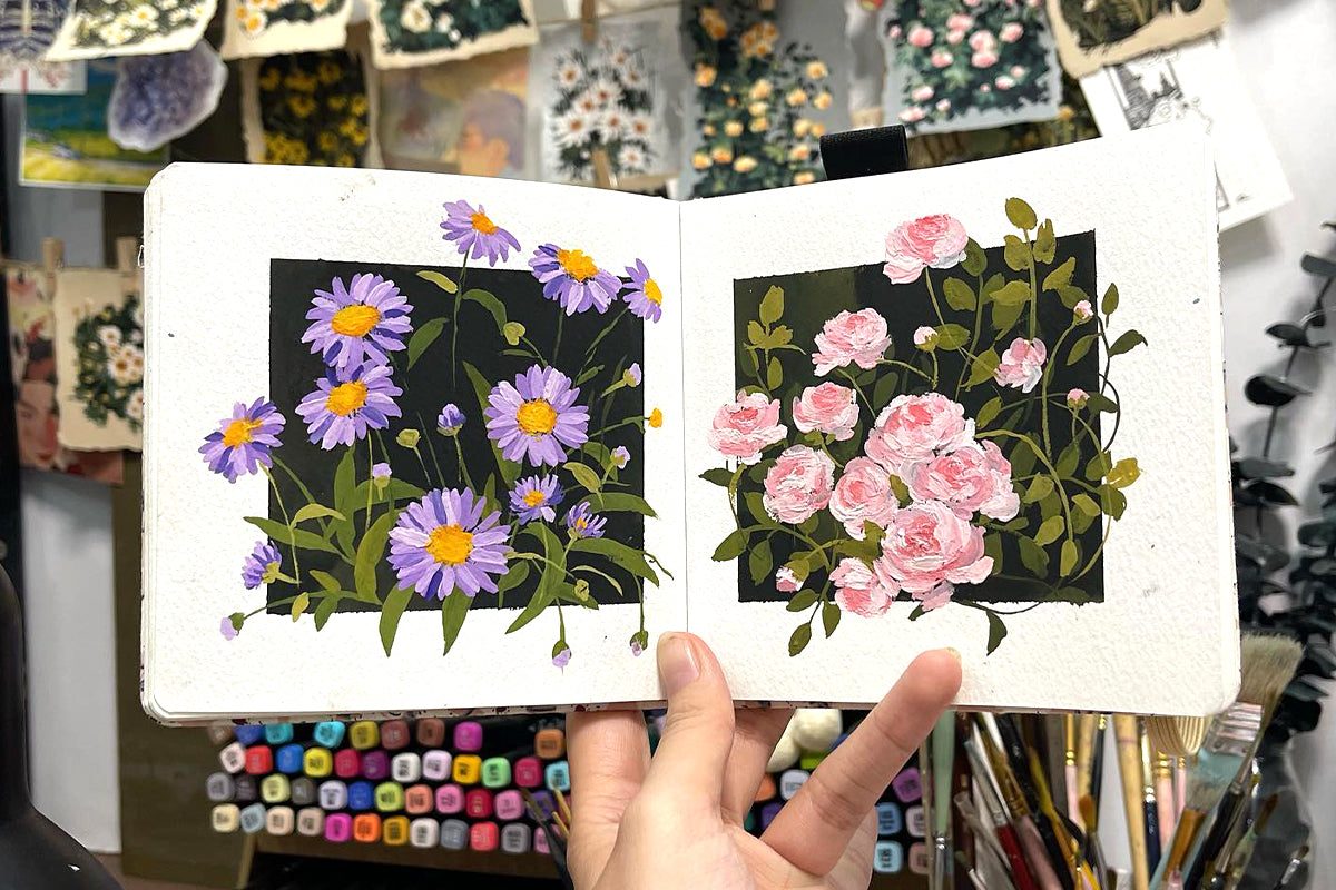 A sketchbook showing two beautiful panels of painted gouache flowers