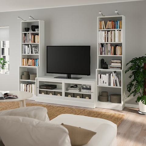 a tv stand surrounded with bookcases