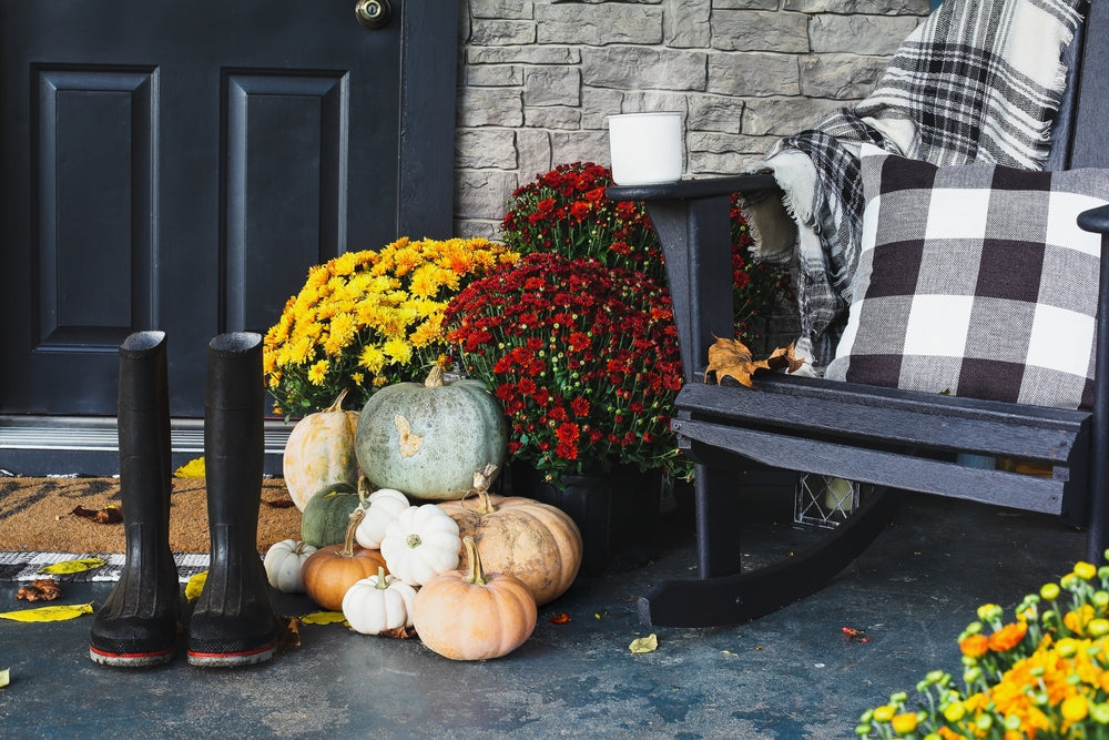 a porch filled with mums and pumpkins