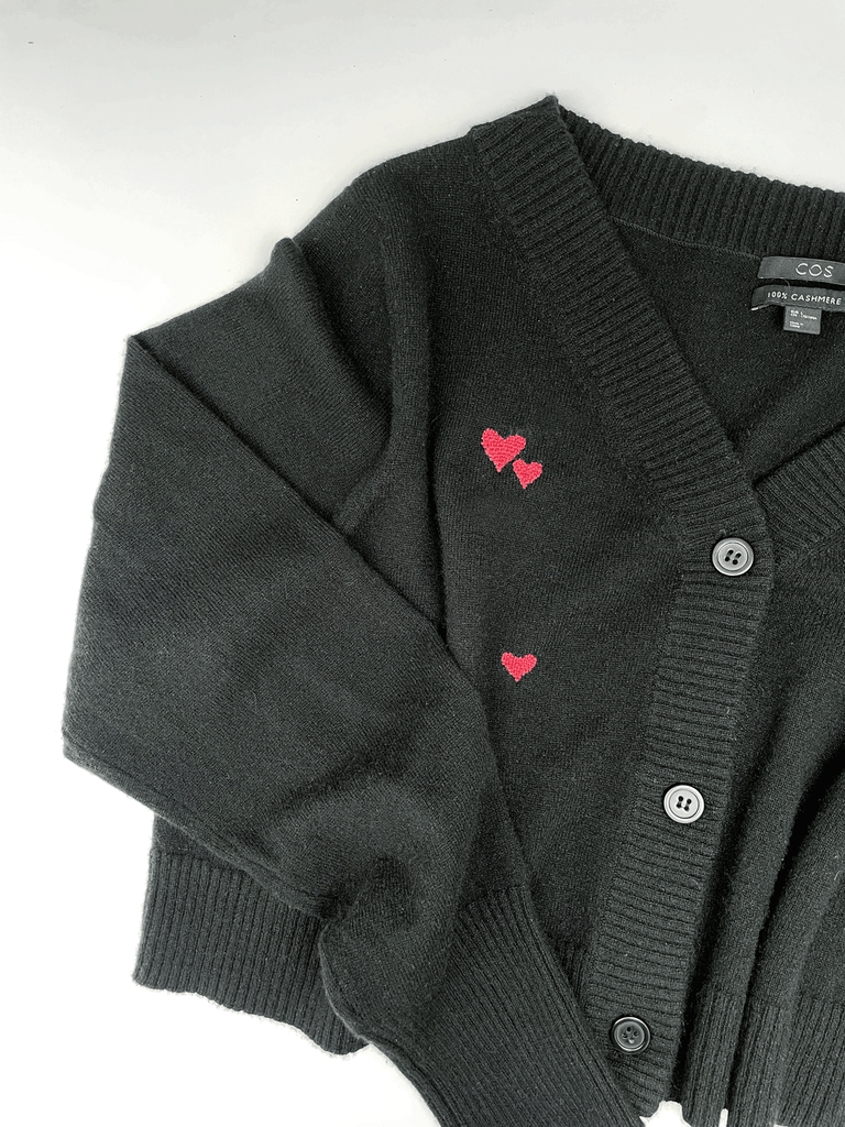 red heart shaped darn visible repairs on a black cashmere cardigan