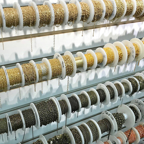 Rows of chain spools containing plated chain in different shapes and colors.