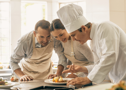 couple attending cooking class with a chef