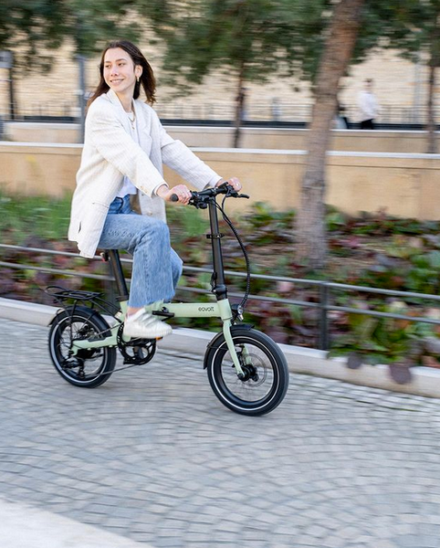 Femme sur un vélo électrique pliant Eovolt morning vert sauge