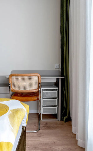 An elegant and functional white dressing table at the foot of a modern bed