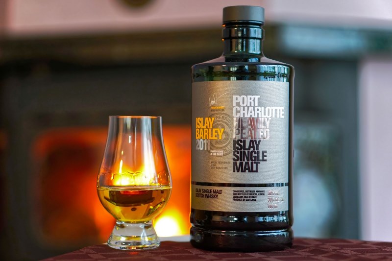 A bottle of Bruichladdich whisky with a glass poured with a generous serving on a table