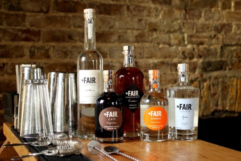 A collection of five assorted bottles of Fair Spirits on a table in a bar setting 