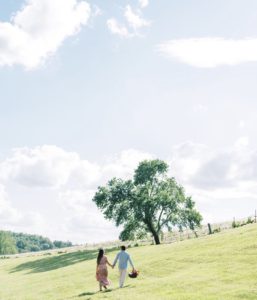 Engaged Couple walking in meadow
