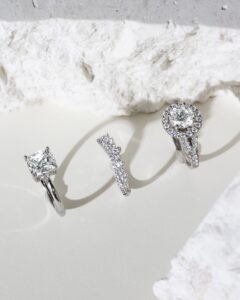 Affordable engagement rings lined up diagonally on a white rock background