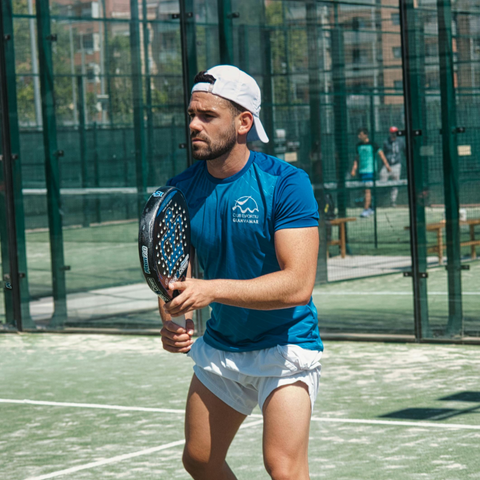 Photo d'un joueur de padel sur le court, raquette en main