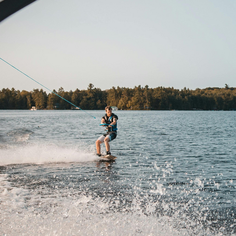 Photo d'un homme en wakeboard sur un lac tracté par un bateau