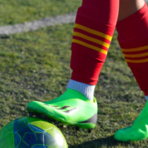 Photo des pieds d'un joueur de football portant des chaussettes coupées