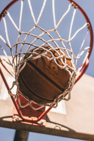 Photo d'un ballon de basket dans les filets du panier