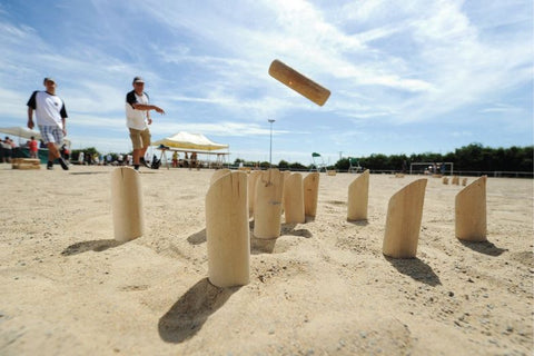 Photo de personnes jouant au molkky sur la plage