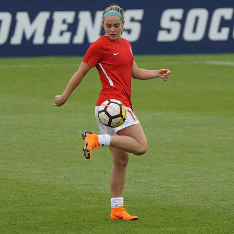 Photo d'une joueuse de football qui jongle avec les chaussettes baissées