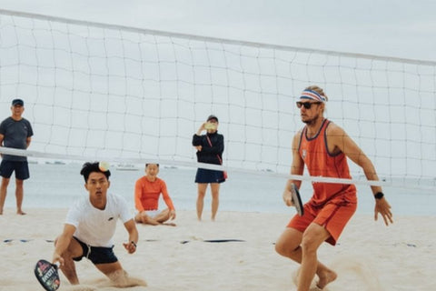 Photo d'hommes jouant au beach tennis sur la plage