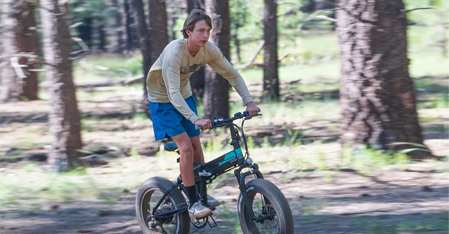 Homme chevauchant un vélo électrique Fiido M1 pro à travers les bois