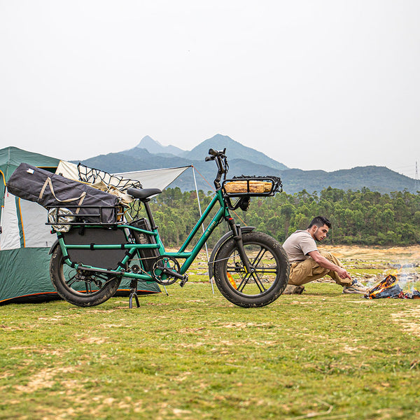 Homme campant avec un vélo électrique à côté de lui