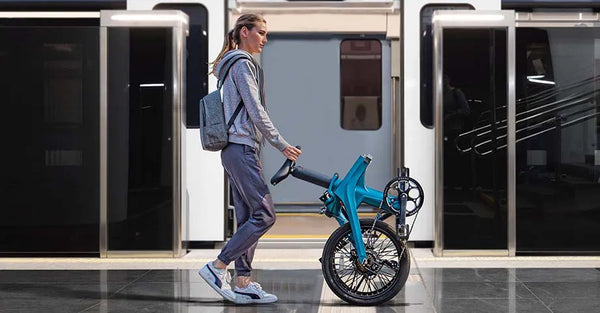 Une femme marchant en poussant un vélo électrique pliant