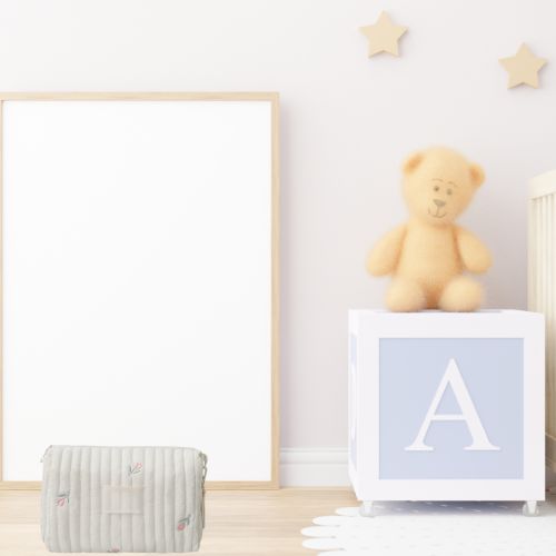 Sac a langer creme au sol dans une chambre pastel avec deco etoiles et ourson.