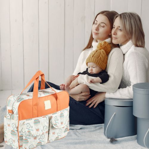 sac bebe montgolfiere avec deux mamans assises et un bébé au bonnet moutarde