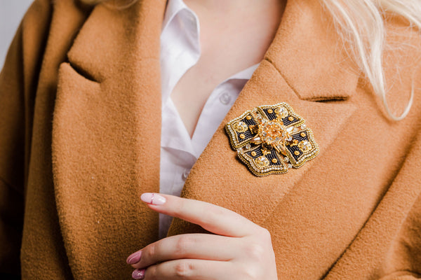 Brooch worn on a camel-colored woman's coat