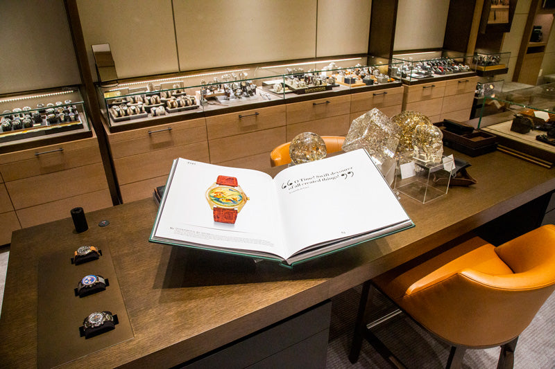 A large open book with information about timepieces is on displace at the central counter.