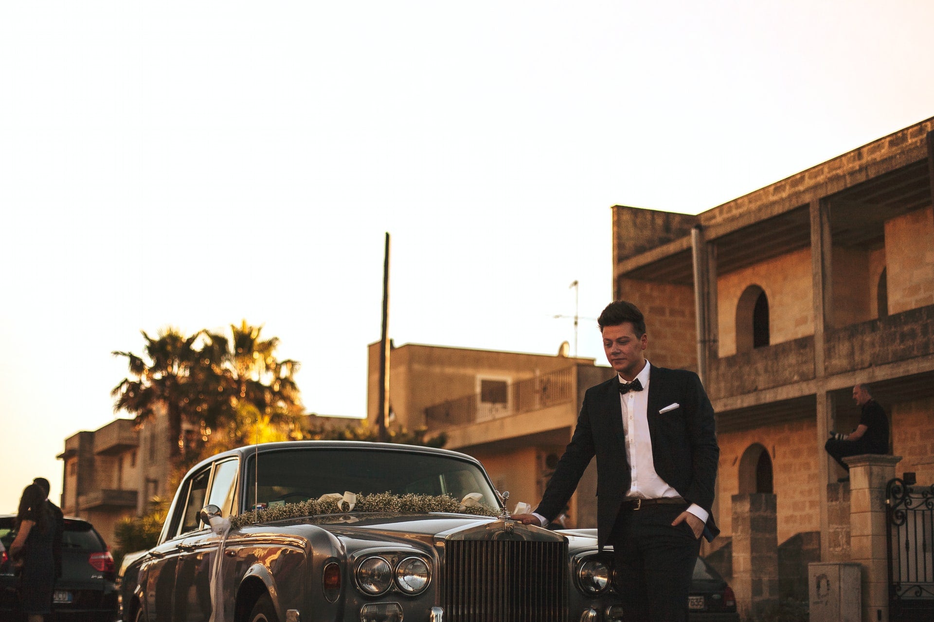 Man in a suit near his car outside