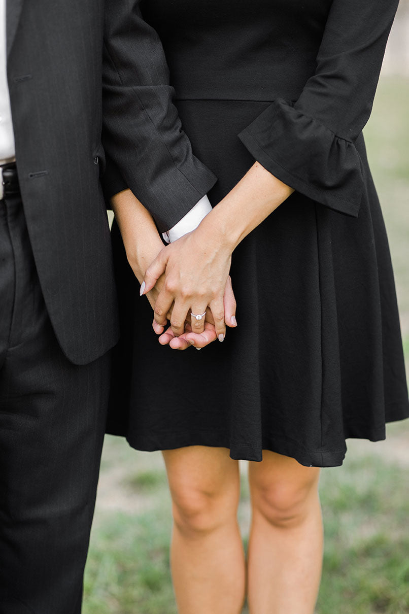 A close up of Jenna & Matt holding hands to show off the engagement ring.