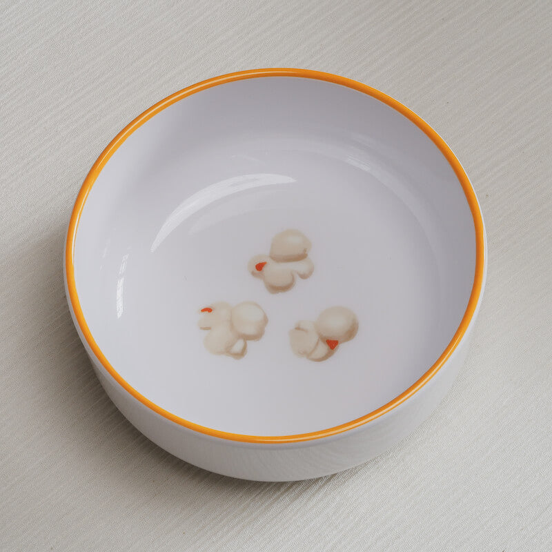 A popcorn Macro Bowl, that has a yellow rim and colorful illustrations of popped popcorn on the bottom of the bowl.